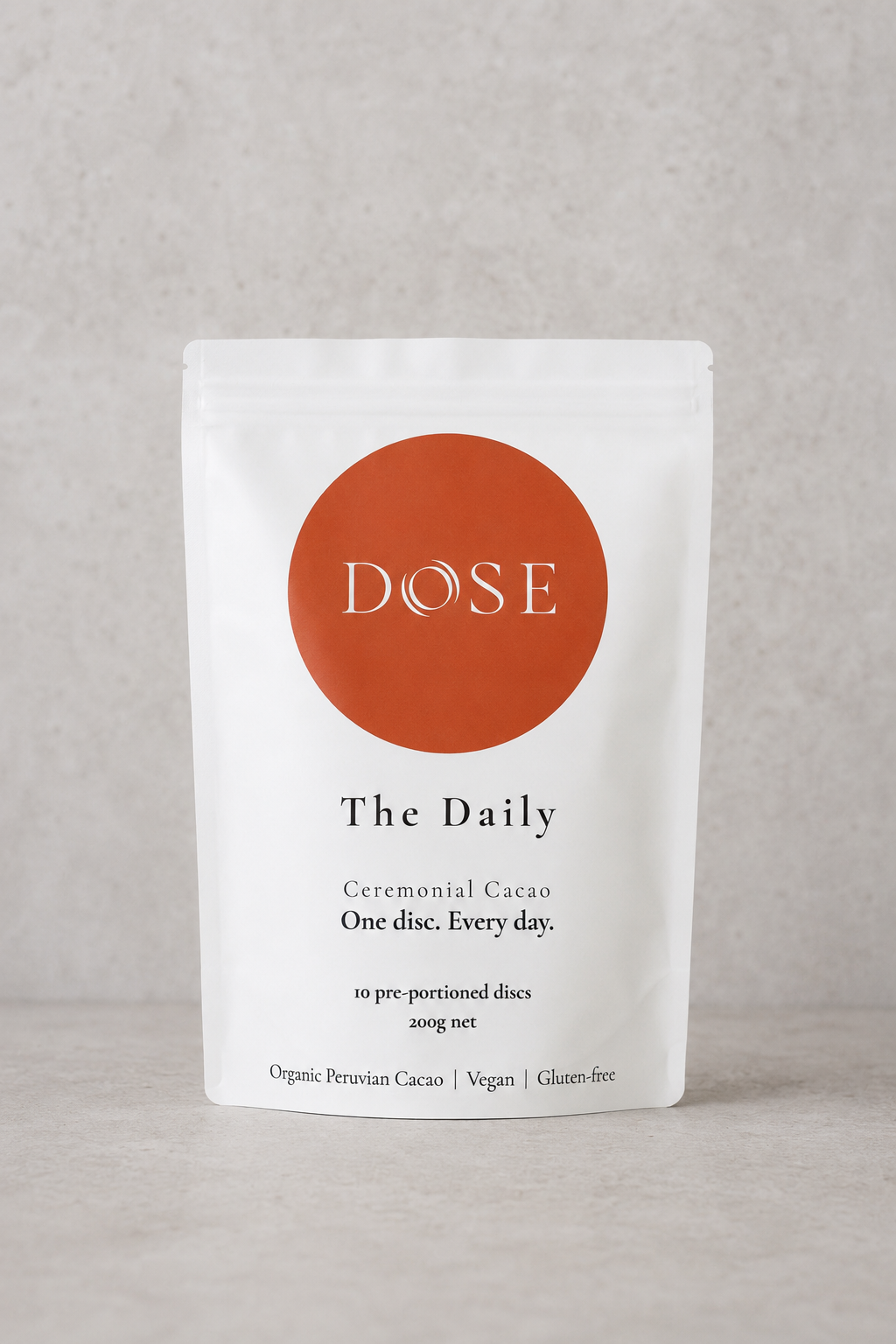 Dose packaging for ceremonial cacao discs on a gray background